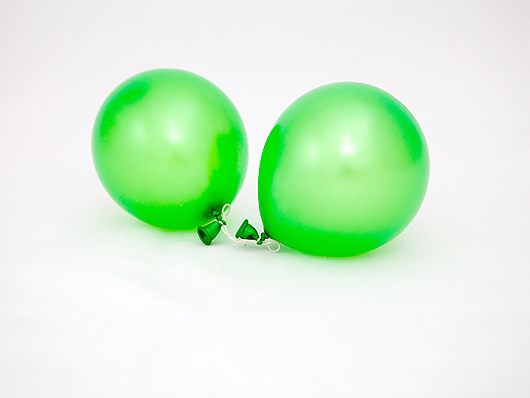  Скрепляем два зелёных воздушных шара канцелярской резинкой 