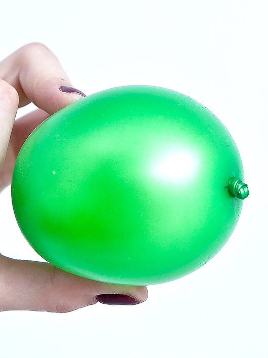  Надуваем зеленый воздушный шар и отрезаем хвостик шарика 
